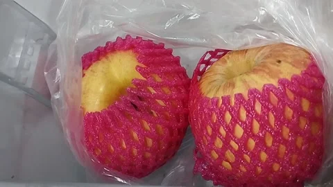 There are two pink apples in clear plastic Stock Footage 229554387