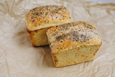 There are two rectangular breads on the paper which is on the table Foto stock