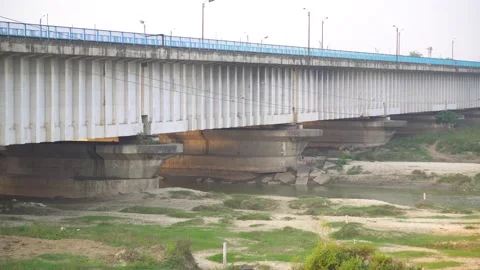 There are views of the support of the bridge over the river Stock Footage 217534741