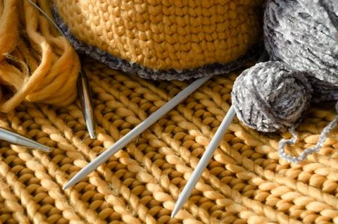 There is a ball of thread and knitting needles on the table. Handmade. Stock Photos