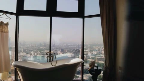 There is a bathtub in front of a large bright window Видео 167497659