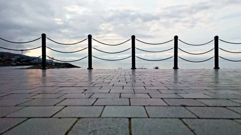There is a bench sitting on the sidewalk by the water Stock Footage 268944842