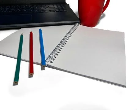 There is a black laptop on a white background. There is a red cup next to it. Stock Photos