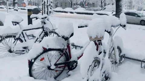 There is a blizzard and heavy snowfall in the city. Bicycles covered with snow  Stock Footage 263908027