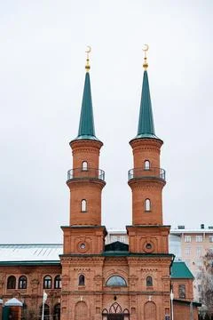 There is a brick building that features two elegant minaret towers graceful.. Fotos de archivo