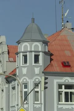There is a building characterized by its red roof and a tower on top Stock Photos