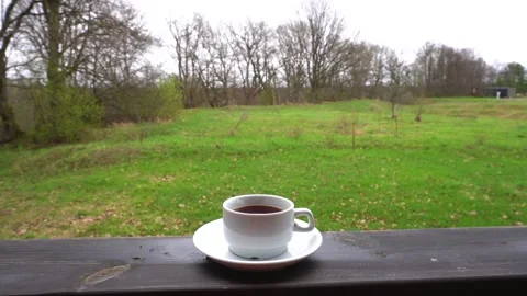 There is a cup of coffee on the outdoor table. Stock Footage 334947882