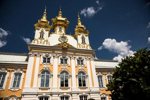 There exists a large building that features a clock situated on its top Stock Photos