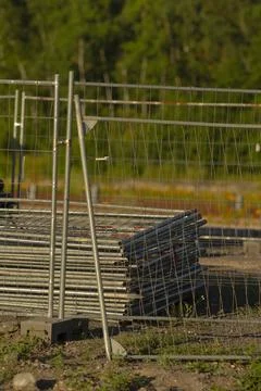 There is a fence that has a stack of scaffolding placed right behind it Stockfoto's