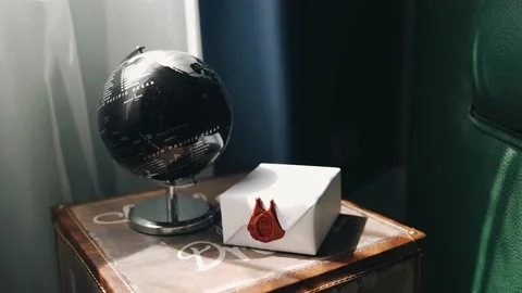 There is a globe and a parcel wrapped in paper on the bedside table Vidéo 160621778