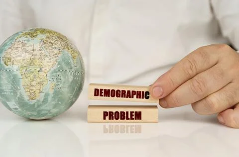 There is a globe on a white reflective surface, in the hands of wooden blocks 写真素材