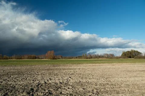 There goes a storm cloud over the field Stock Photos