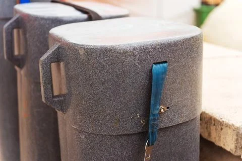 There is a gray container that has a blue strap attached to it Stock Photos