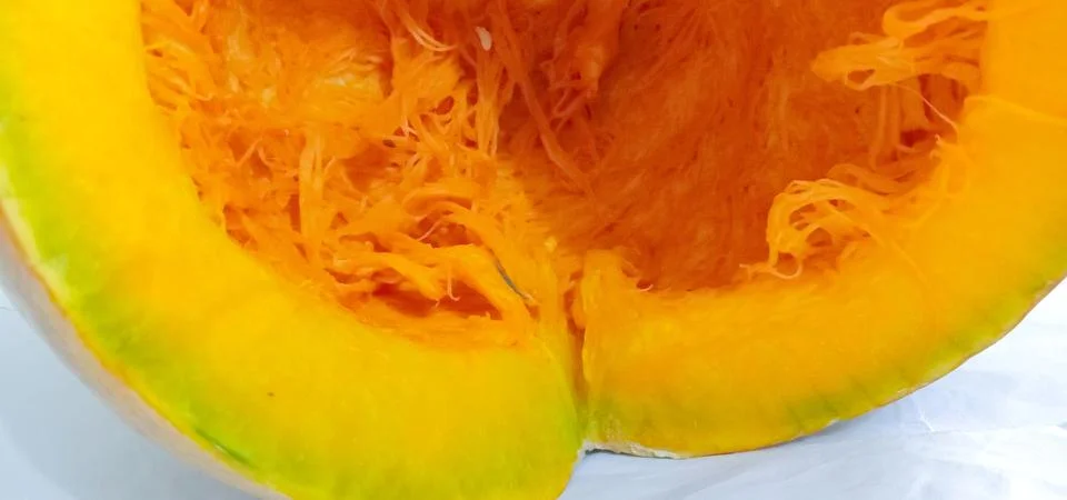 There is a half pumpkin on the bed sheet Foto stock