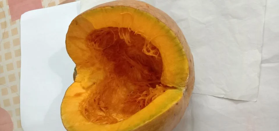 There is a half pumpkin on the bed sheet Stock Photos
