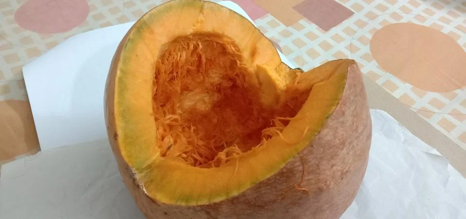 There is a half pumpkin on the bed sheet Stock Photos