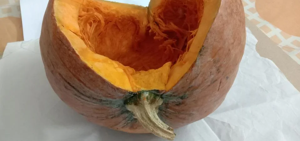 There is a half pumpkin on the bed sheet Stock Photos