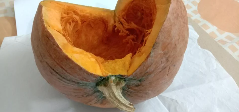 There is a half pumpkin on the bed sheet Stock Photos