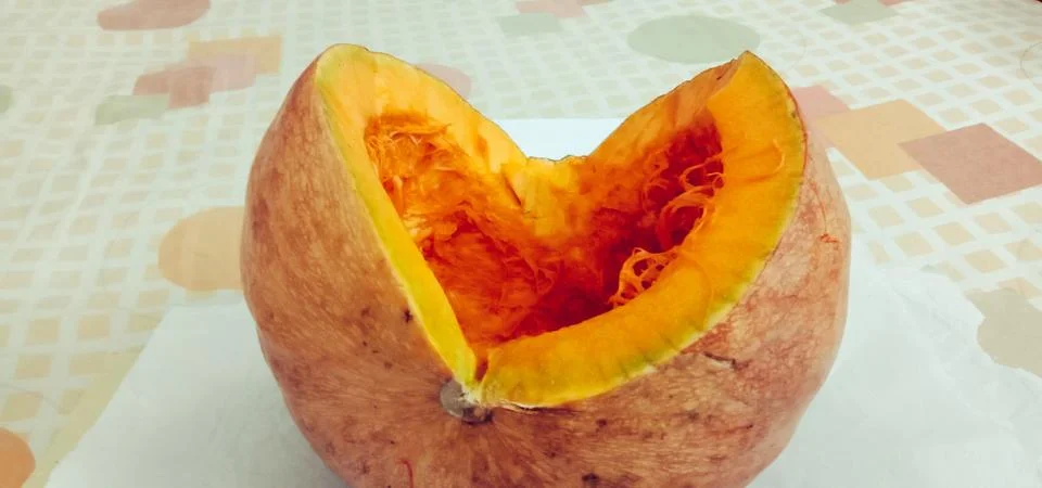There is a half pumpkin on the bed sheet Stock Photos