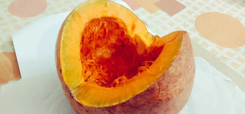 There is a half pumpkin on the bed sheet Stock Photos