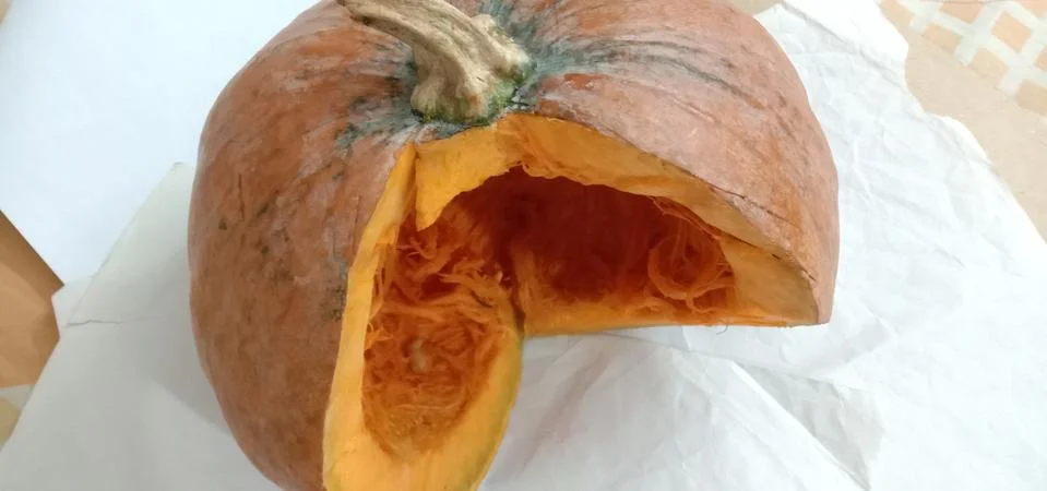 There is a half pumpkin on the bed sheet Stock Photos