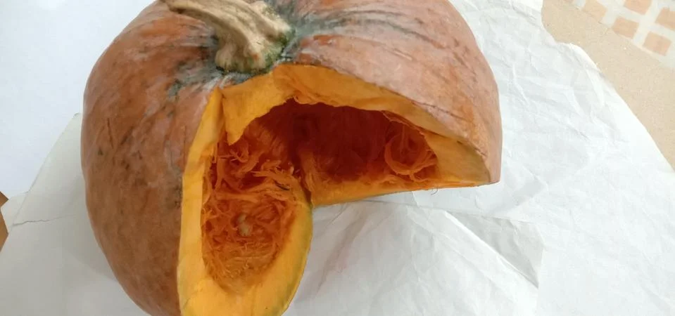 There is a half pumpkin on the bed sheet Stock Photos