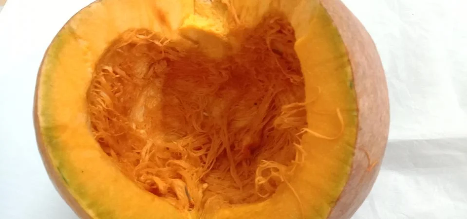 There is a half pumpkin on the bed sheet Foto stock