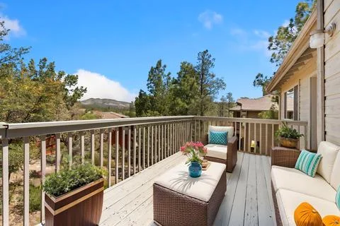 There is a large deck area that features a cozy couch and several chairs on i Stock Photos