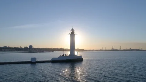 There is a lighthouse on the sea. Behind him was the sun. The sun's rays Stock Footage 121834320