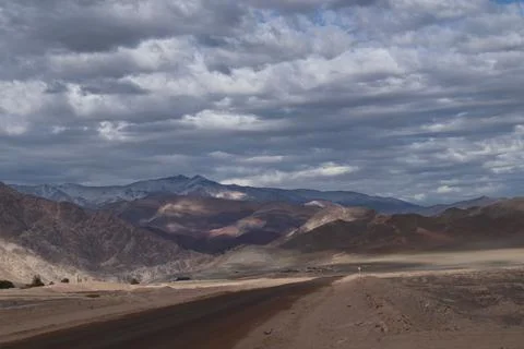 There is a long empty road going through the desert to nowhere Stock Photos