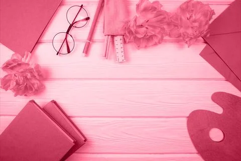 There is a notebook, flowers, books on the table. The color of the year 2023. Stock Photos