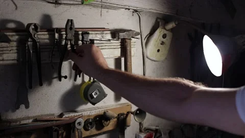 There is an old tool in the garage, the man gets to work Stock Footage 214086165