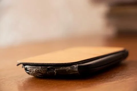There is an old touch mobile phone covered with tape on the table, phone re.. Stock Photos