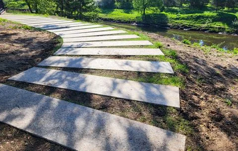 There is a path made of concrete rectangles between the trees in the park. Th Stockfoto's