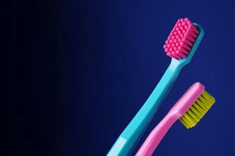 There is a place for text. Two bright plastic toothbrushes on a dark blue bac Foto stock