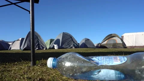 There is plastic bottle on the ground in the camp Vídeos de archivo 205214730