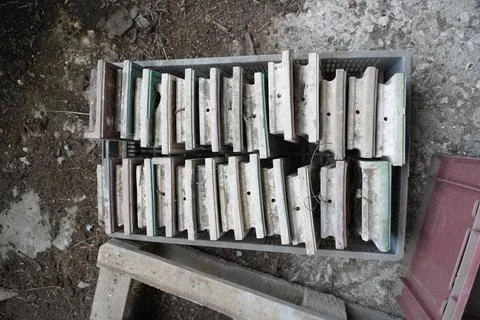 There is a plastic box filled with old ceramic tiles on the ground. Stock Photos