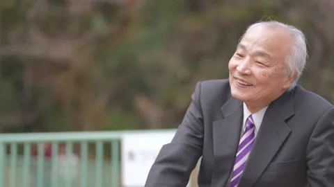 There is plenty of greenery in the spring noon park in Japan. A Japanese man Vídeo Stock 307378364