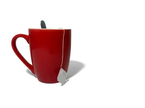 There is a red cup on a white background. The cup contains a teaspoo Stock Photos