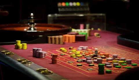 There is a red table with roulette chips in the casino Stock Photos