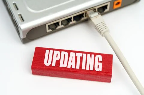 There is a router connected to the network on the table, next to a plaque wit Stock Photos