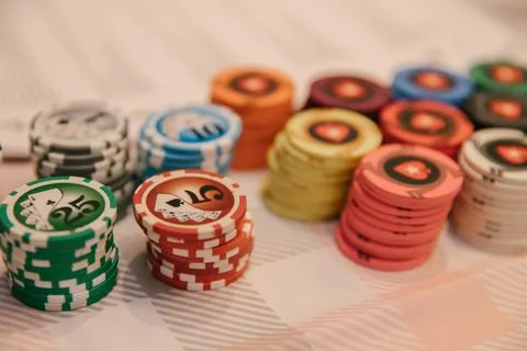 There is a stack of chips and cards on the table for playing at the wine casino Stock Photos