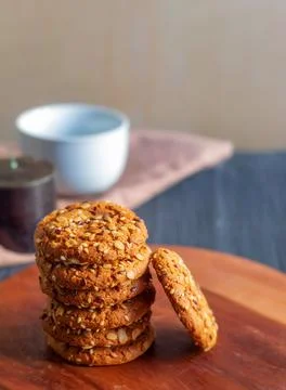 There is a stack of fresh oatmeal cookies on a wooden round board Stockfoto's