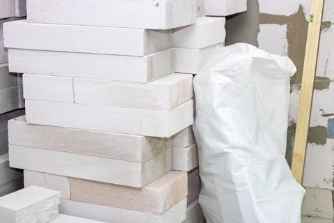 There is a stack of white bricks located next to a white bag Foto stock