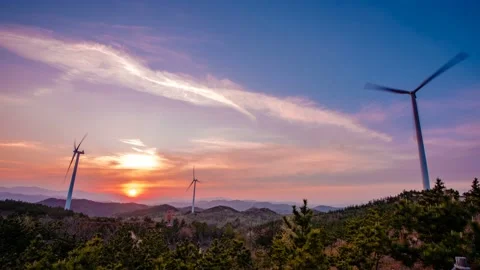 There is a sunset over the hill where the wind generator is seen. time lapse. 動画素材 145889697