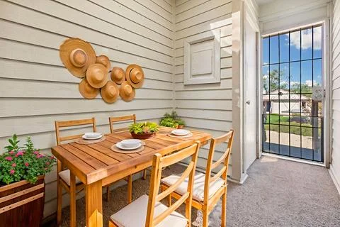 There is a table and some chairs arranged neatly on the porch of a house Stock Photos