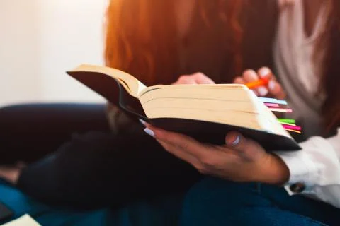There is a thick big book with multi-colored bookmarks close-up. Two red-haired Stock Photos