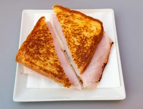 There is thin slice of soft and juicy ham between two slices of bread. Stock Photos