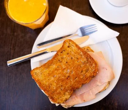 There is thin slice of soft and juicy ham between two slices of bread. 스톡 사진