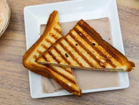 There is thin slice of soft and juicy ham between two slices of bread. Stock Photos